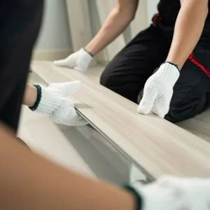 Craftsperson installing wood-look flooring boards